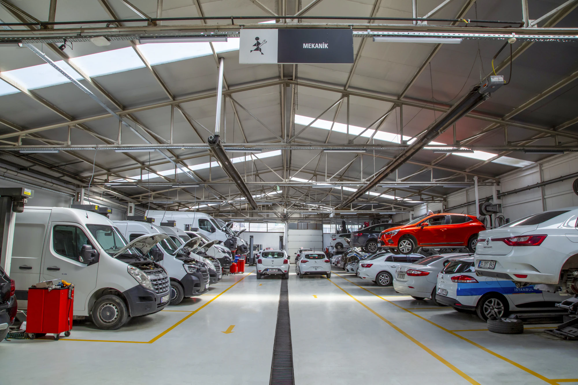 A bright, clean service bay with cars on lifts